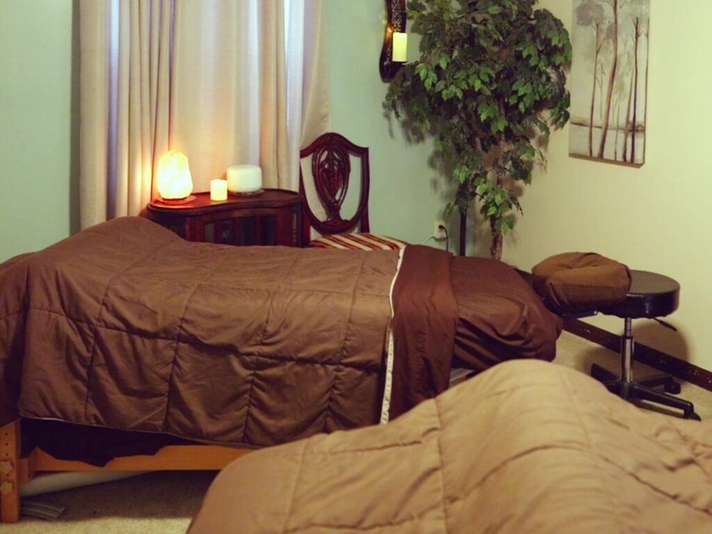Couples massage room at Blue Mountain Mist Spa with two massage tables, soft lamp light and candles