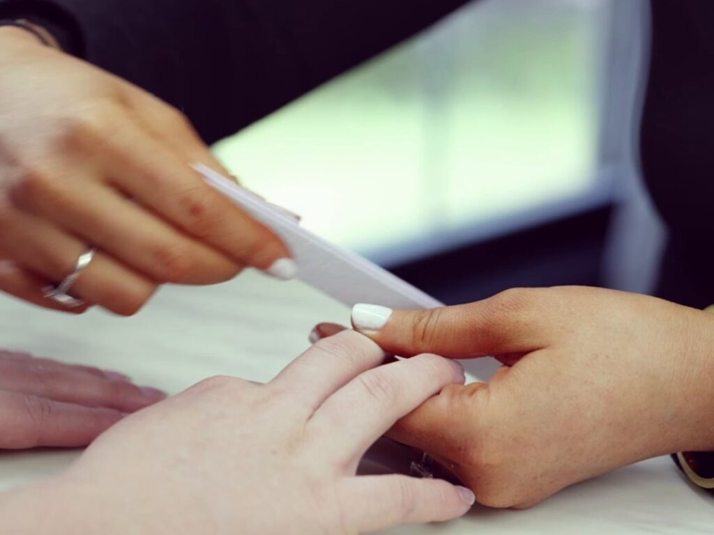 Nail technician filing a guest's nails during a manicure at Blue Mountain Mist Spa